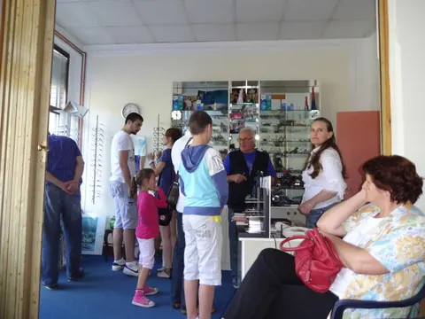 Unutrašnjost prodajnog prostora Optike Mila sa mušterijama i vitrinama sa naočarima